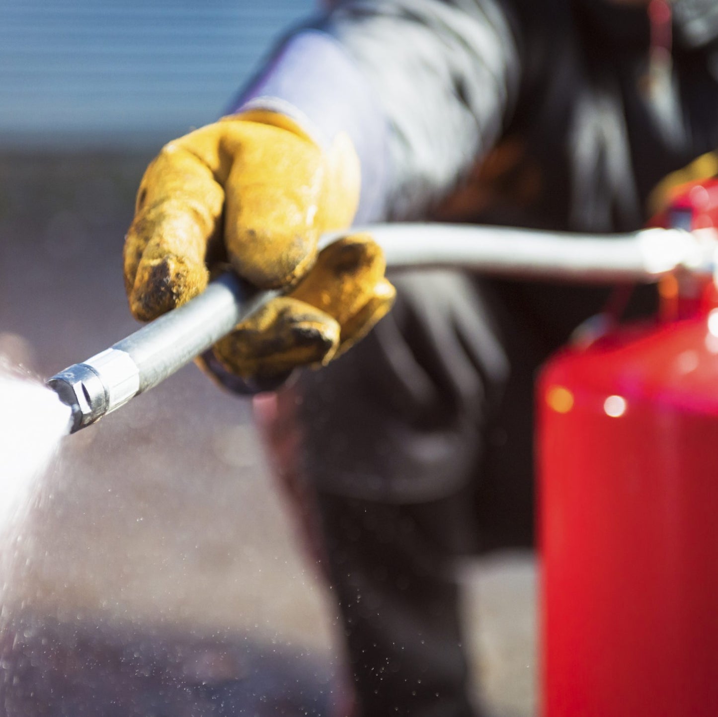 Person using a fire extinguisher with a blurred background